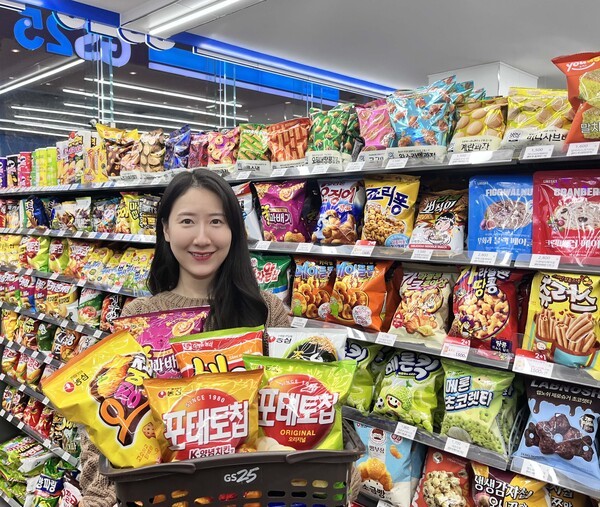 GS25에서 모델이 농심 스낵 골라담기 행사 상품을 들고 포즈를 취하고 있다. / 사진 GS리테일