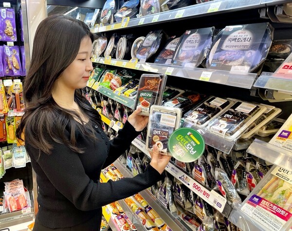 CU 모델이 편의점에서 50% 파격 할인된 간편식을 살펴보고 있다. / 사진 BGF리테일